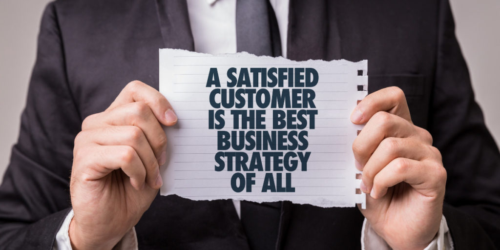 CSI: man holding paper that says "A satisfied customer is the best business strategy of all"