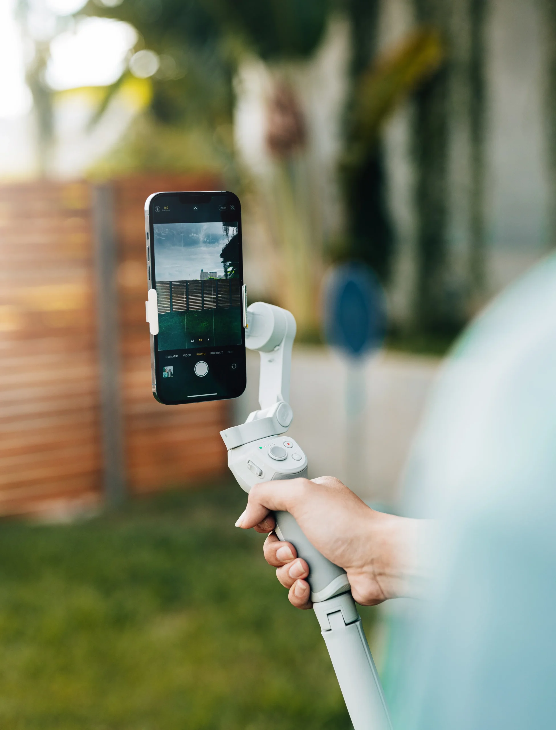 Person holding a selfie stick with a phone in it taking a photo