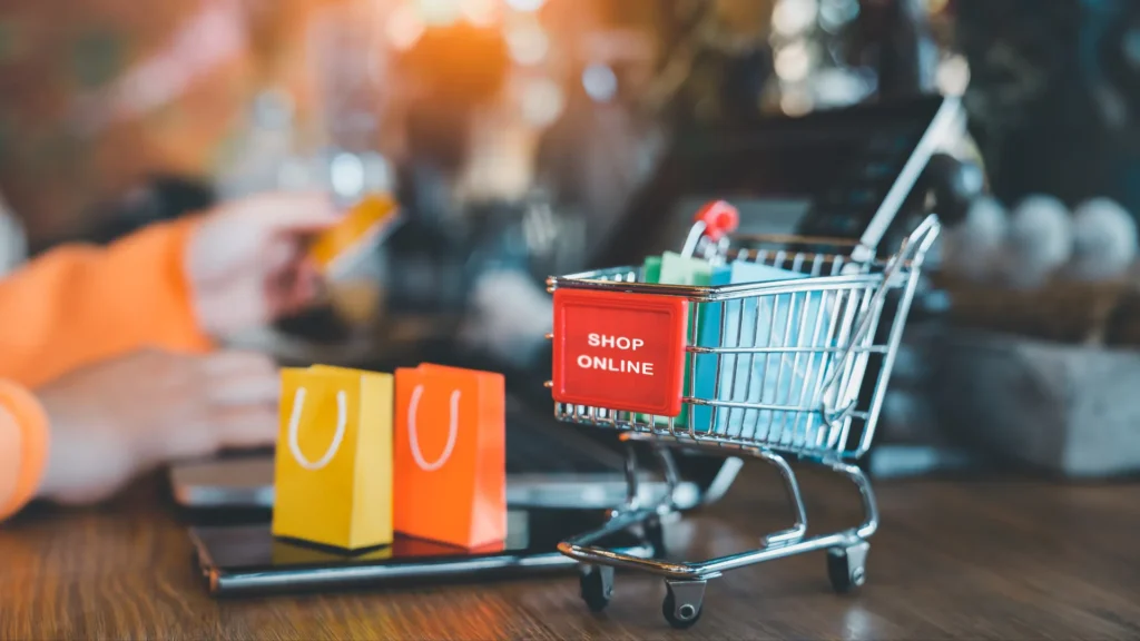 Holiday Advertising Strategy for Online Shopping - shopping cart sitting on top of table with giftbags