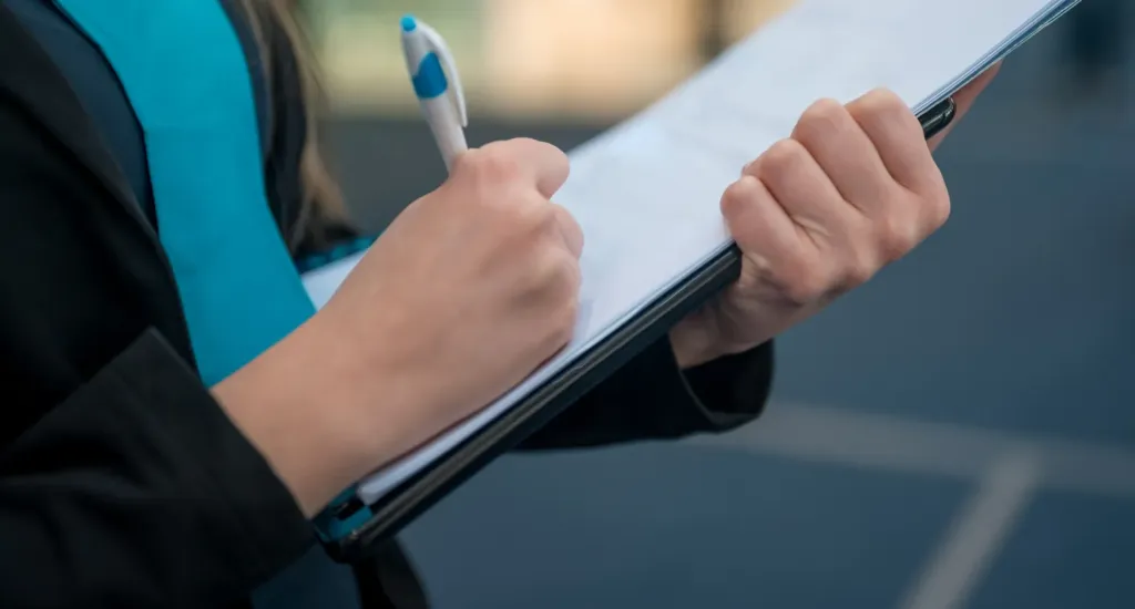 woman holding folder with paper and pen